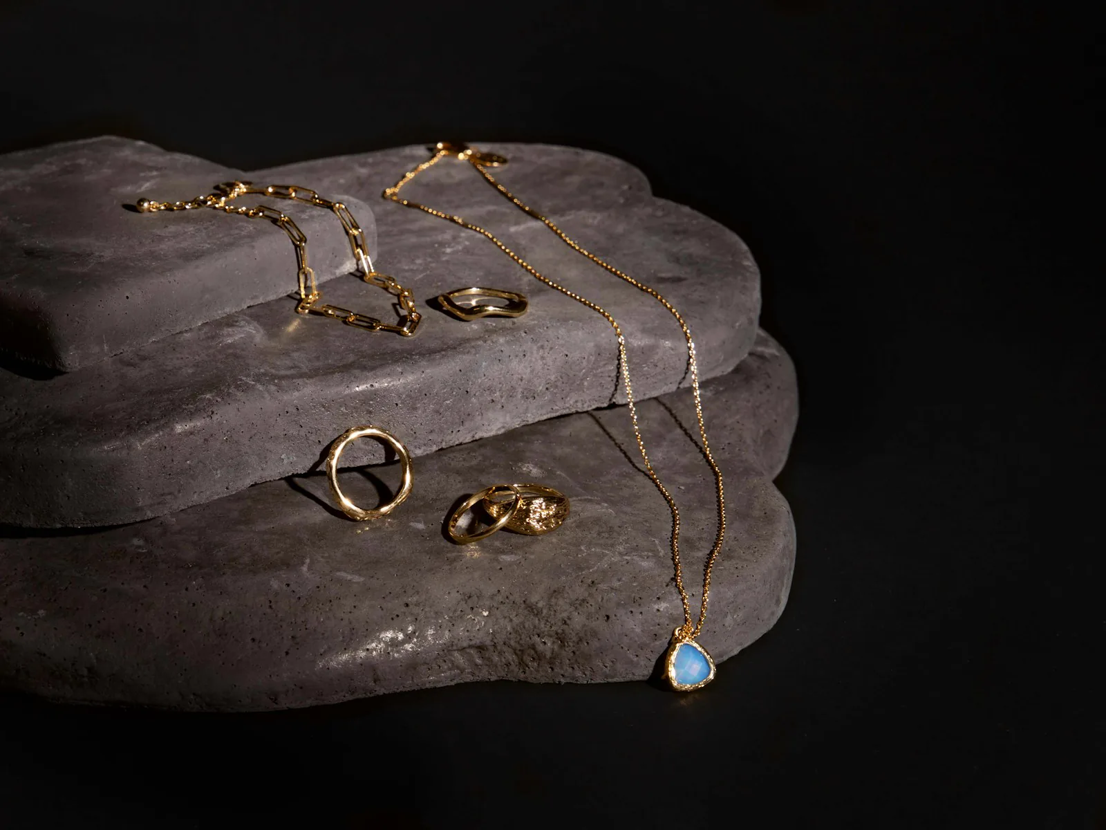 Joyería sobre piedra oscura y metal frío